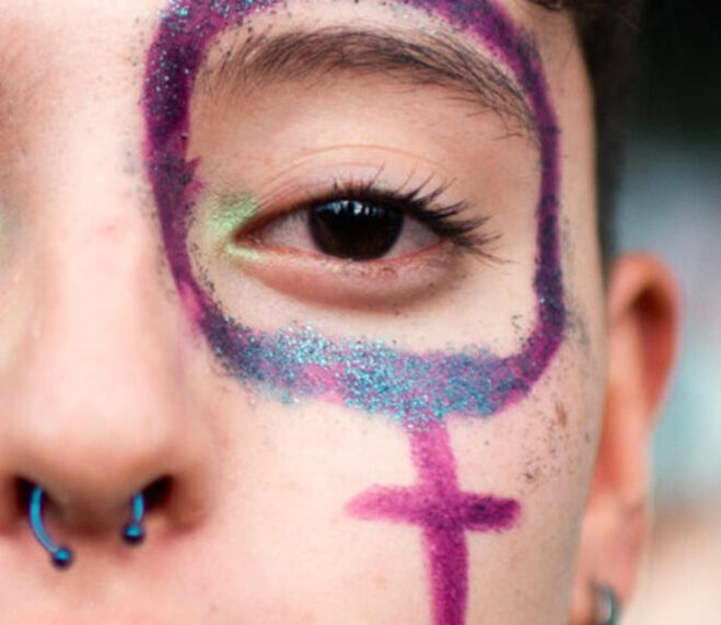 Una mujer con la cara pintada participa en una manifestación en conmemoración del Día Internacional de la Mujer