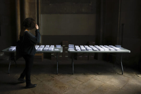 Una mujer observa las papeletas en el colegio electoral instalado en la Universitat de Barcelona este domingo.