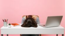 Una joven frustrada mujer exhausta colocó su cabeza sobre la mesa.