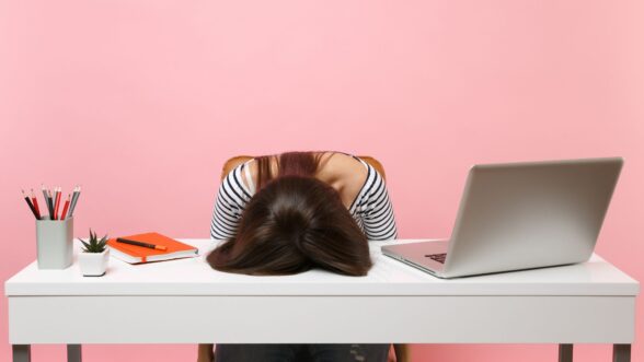 Una joven frustrada mujer exhausta colocó su cabeza sobre la mesa.