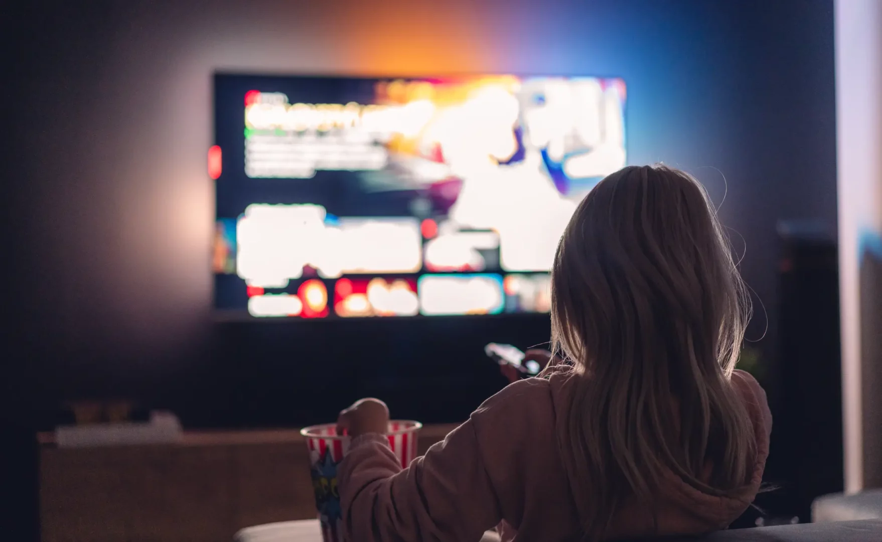 Mujer viendo la televisión de noche Mujer viendo la televisión de noche