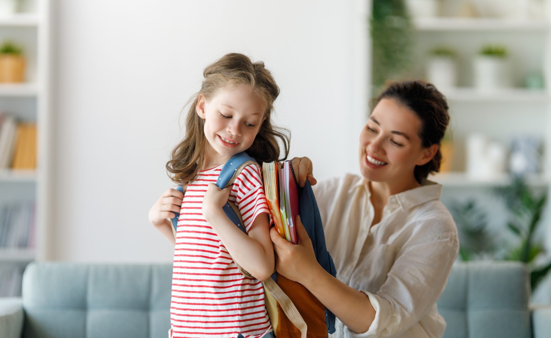 Una madre ayuda a su hija con sus cosas de clase Una madre ayuda a su hija con sus cosas de clase